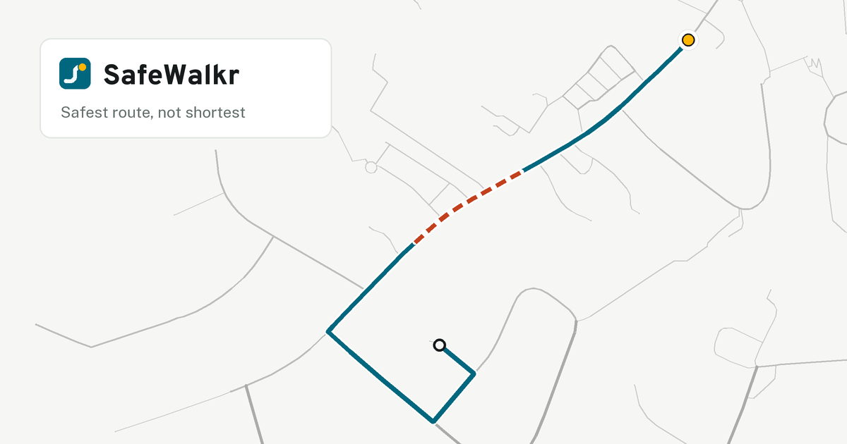 A teal walking route with a white casing across a real street map, from a home at the bottom to a gold school pin at the top right, with one stretch dashed in red where the street has no sidewalk.