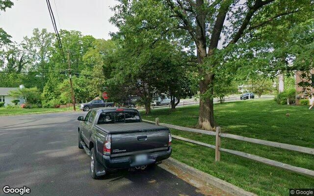 Street View capture of a dead-end residential block, a parked pickup jutting into the roadway and no sidewalk